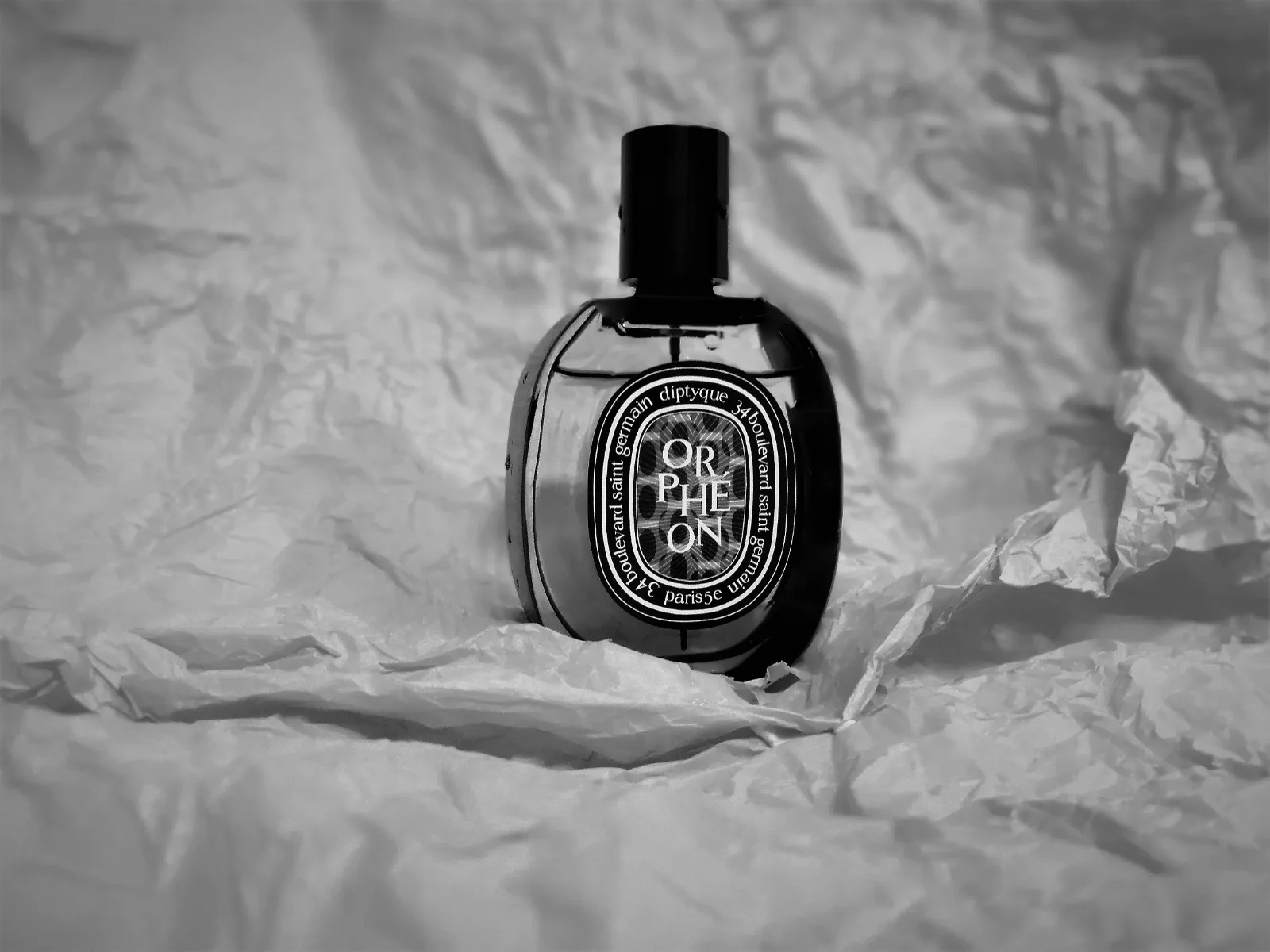 Diptyque Orphéon perfume bottle with notes of tonka bean, cedarwood, and powdery musk, capturing its unique scent profile