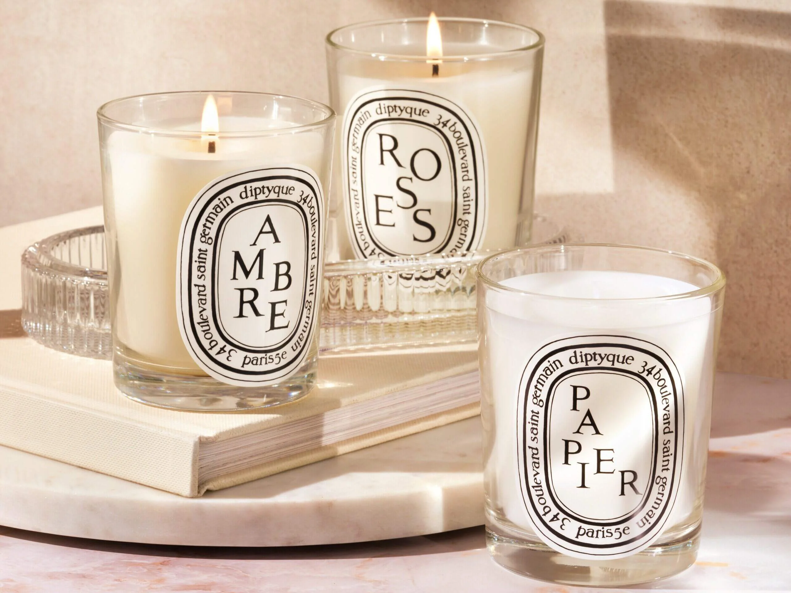 Three Diptyque candles showcasing the brand’s commitment to sustainability and ethical candle production.