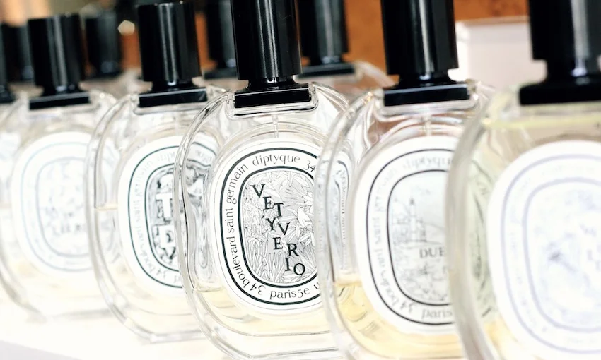 Multiple Diptyque perfume bottles displayed artistically, symbolizing the intricate craftsmanship behind each fragrance.